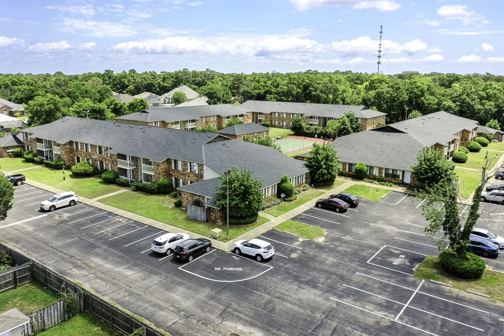 A parking lot with cars and a building in the background.