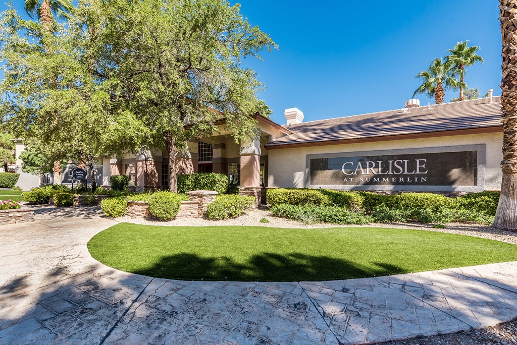 a circular lawn in front of a house with a sign