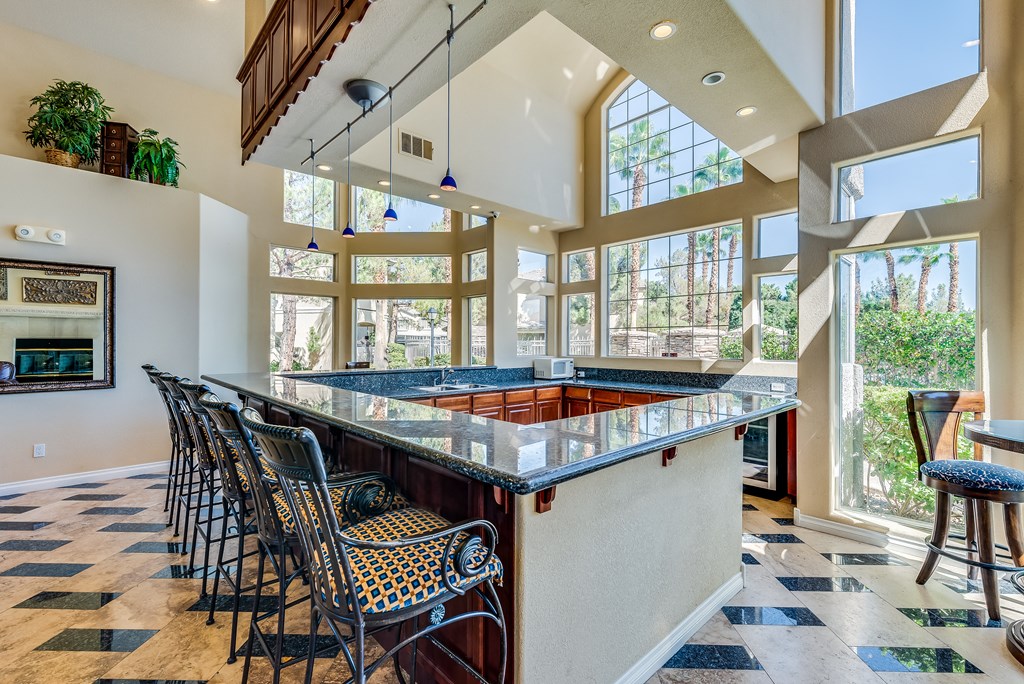 the large bar in the kitchen of a house with large windows