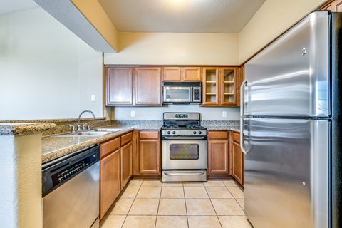 an updated kitchen with stainless steel appliances and granite counter tops