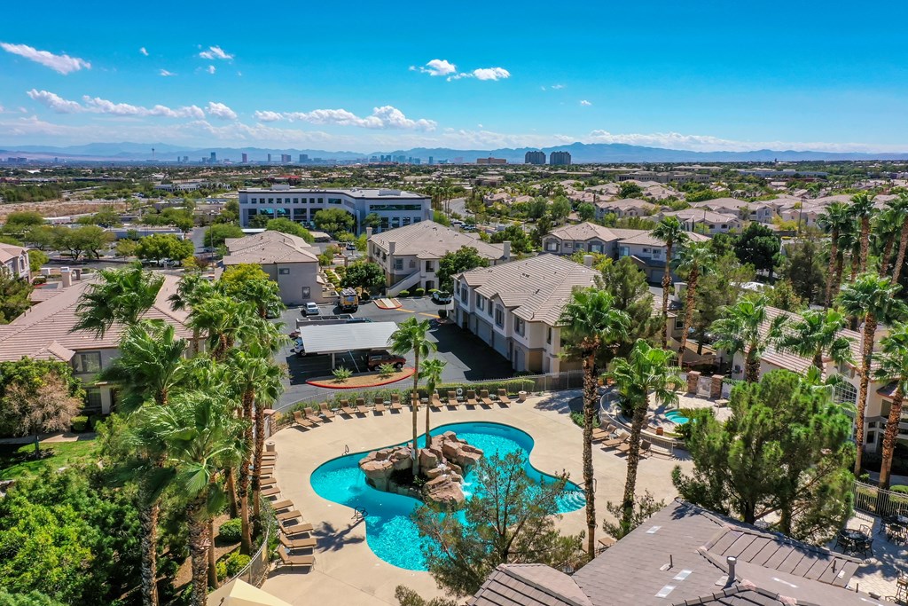 an aerial view of a community with a pool and palm trees