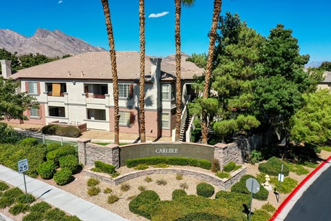 a building with a sign in front of it with palm trees