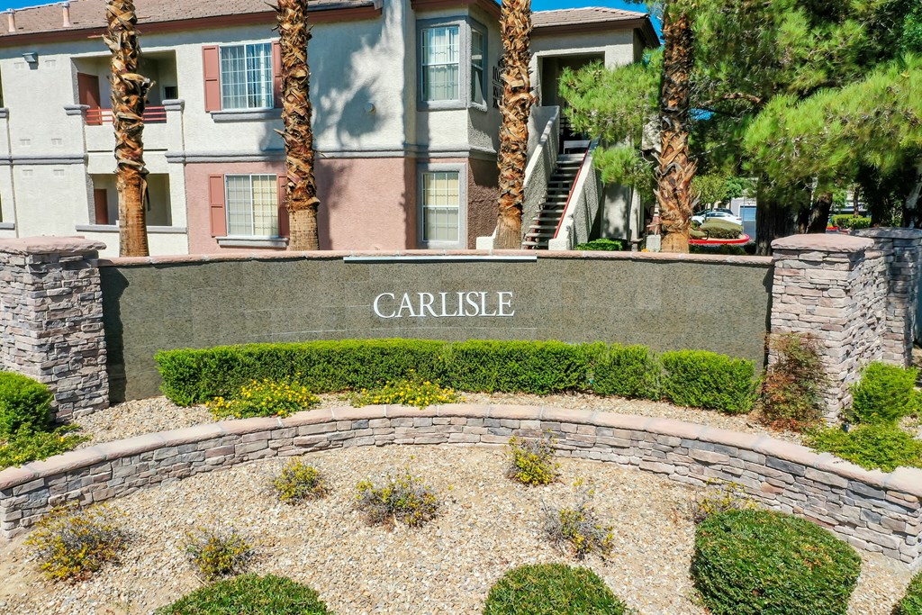 a building with a sign that says in front of a retaining wall