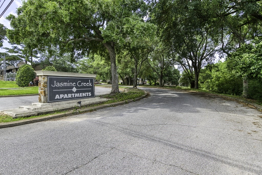 The image shows a street view of Jasmine Creek Apartments.