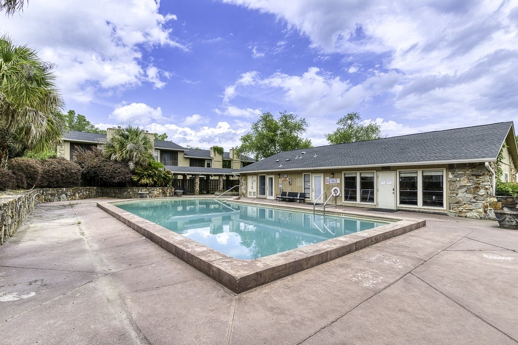 A swimming pool in a backyard with a house in the background.