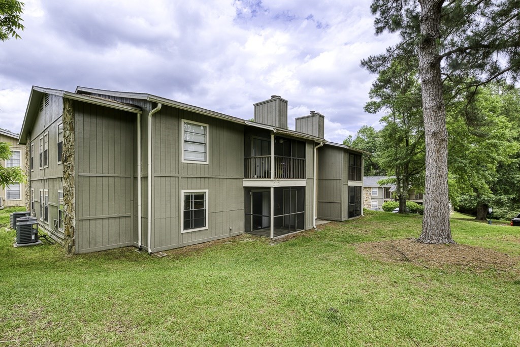 A house with a grey exterior and a tree in front of it.
