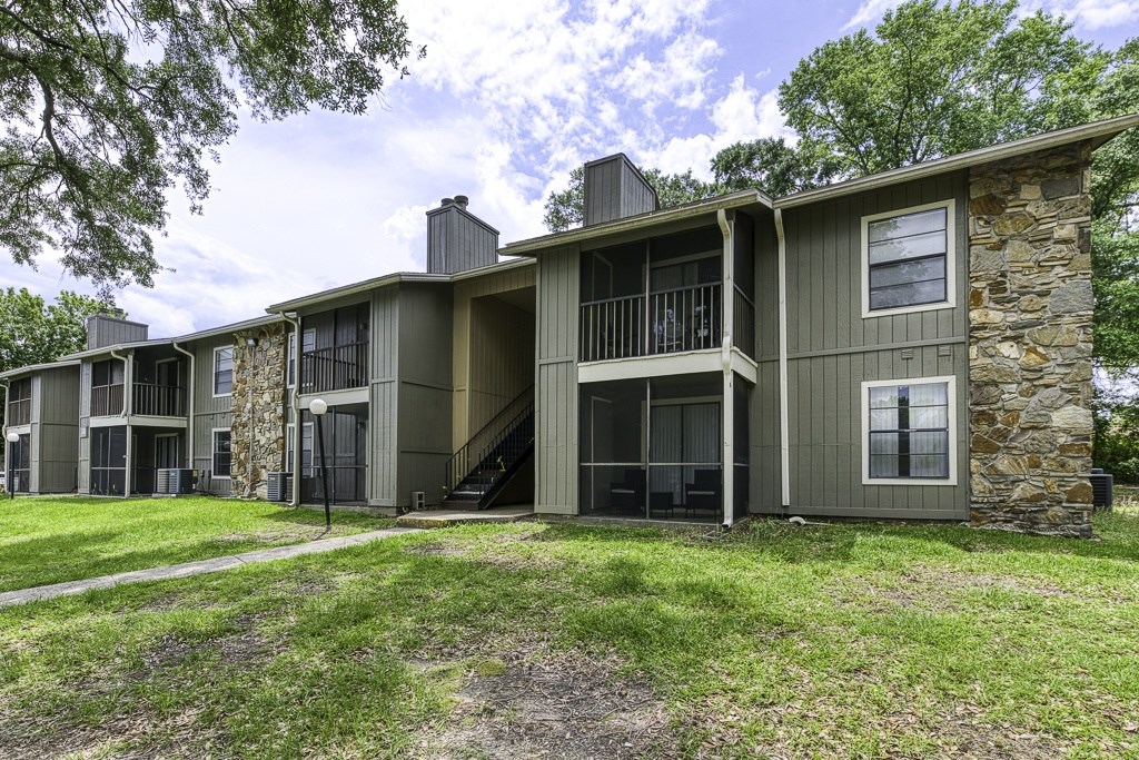 A row of houses with a green lawn in front.