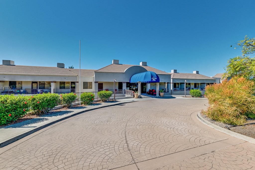 A building with a blue awning is surrounded by a brick walkway.