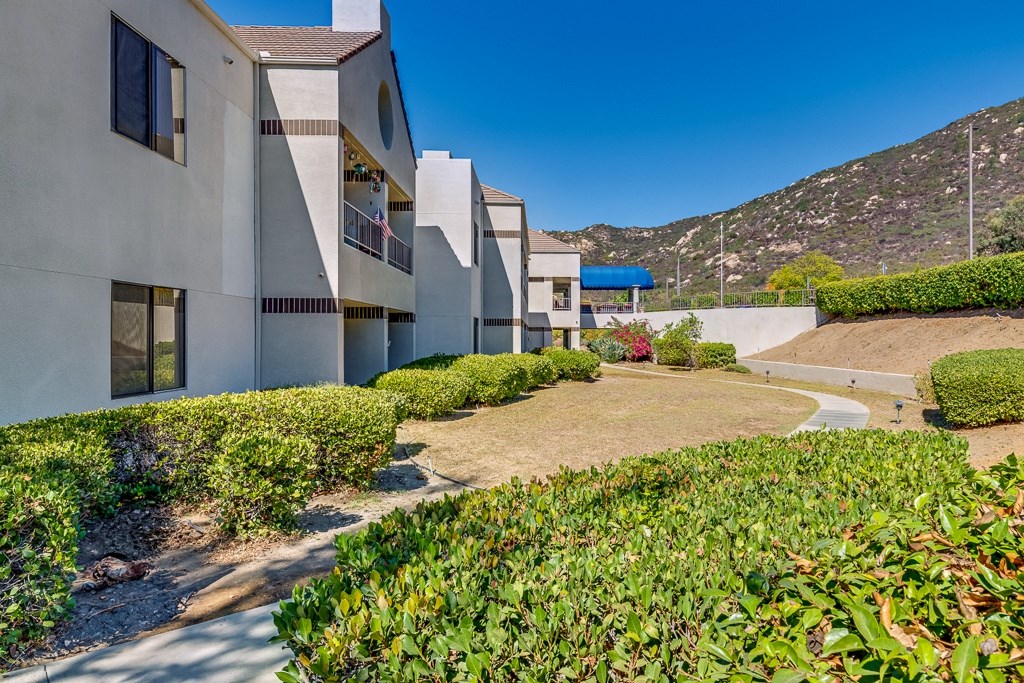 A row of modern houses with green bushes in front.