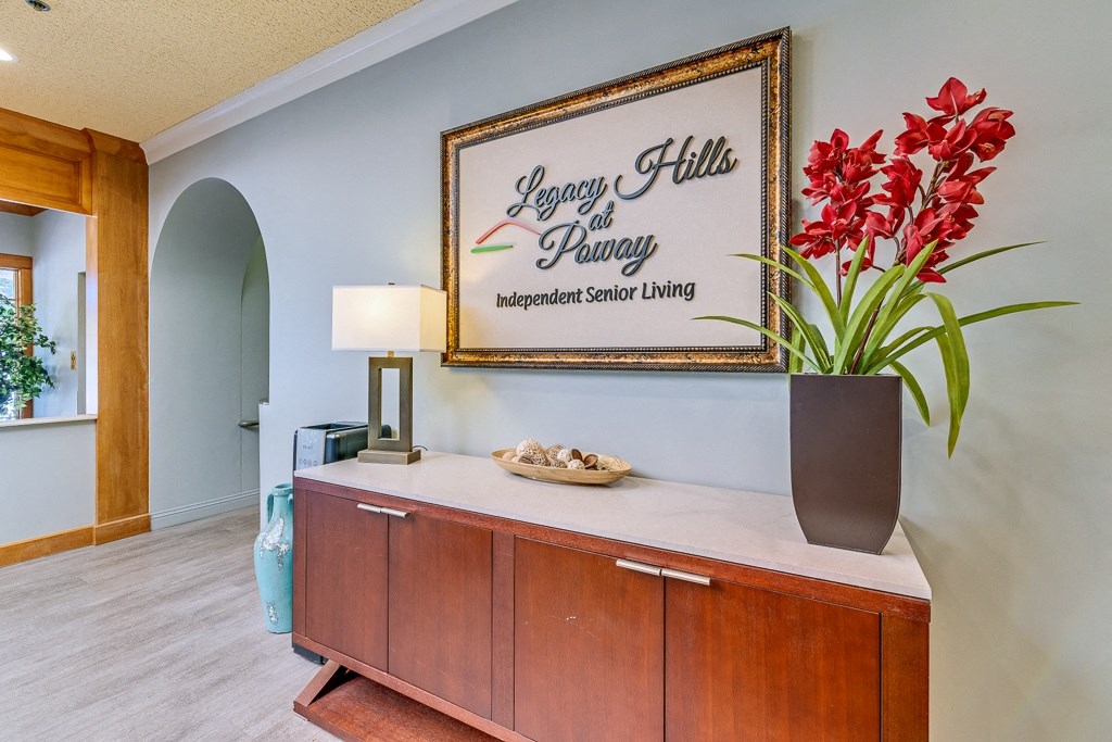 A reception desk with a sign that says "Legacy Hills at Parkway Independent Senior Living".