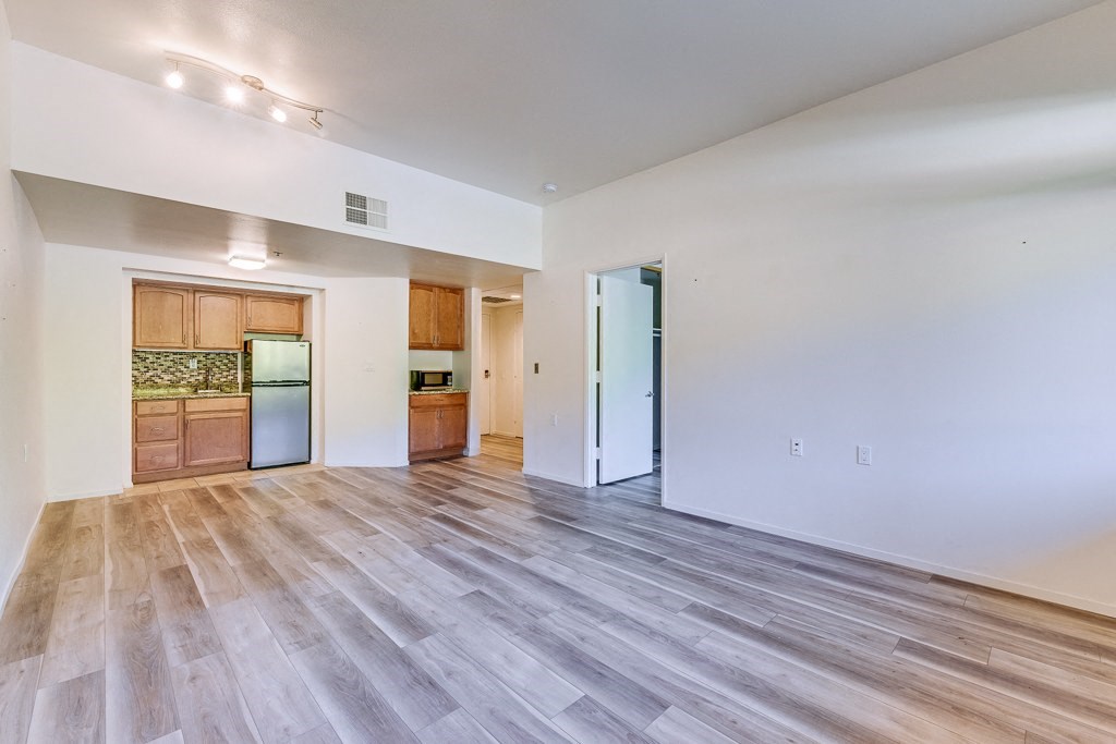 A room with wooden flooring and white walls.