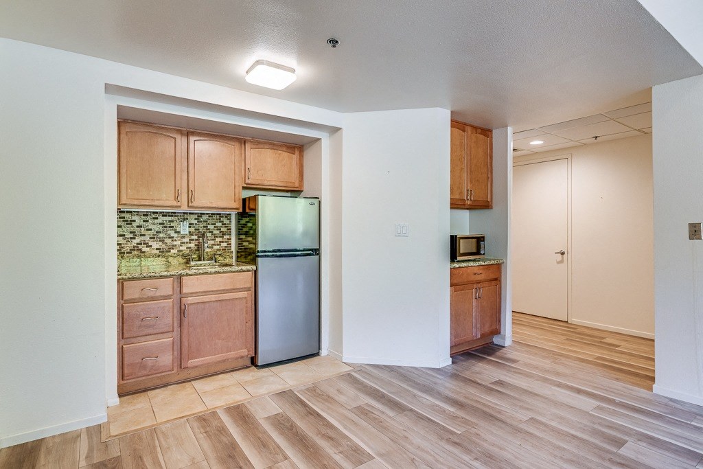 A kitchen with wooden cabinets and a tiled backsplash.