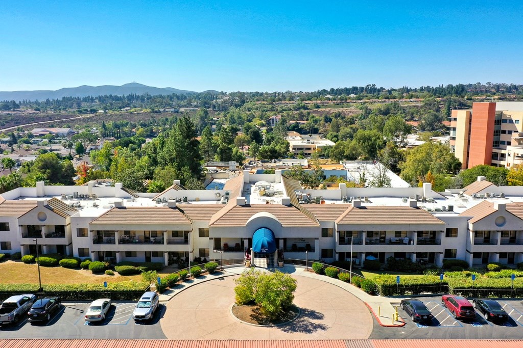 A large building with a blue arched entrance in the middle of a parking lot.