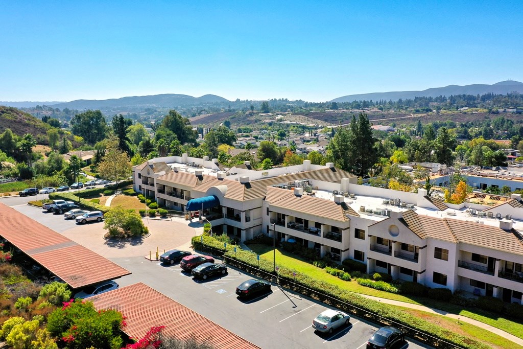 A parking lot in front of a building with a mountain in the background.