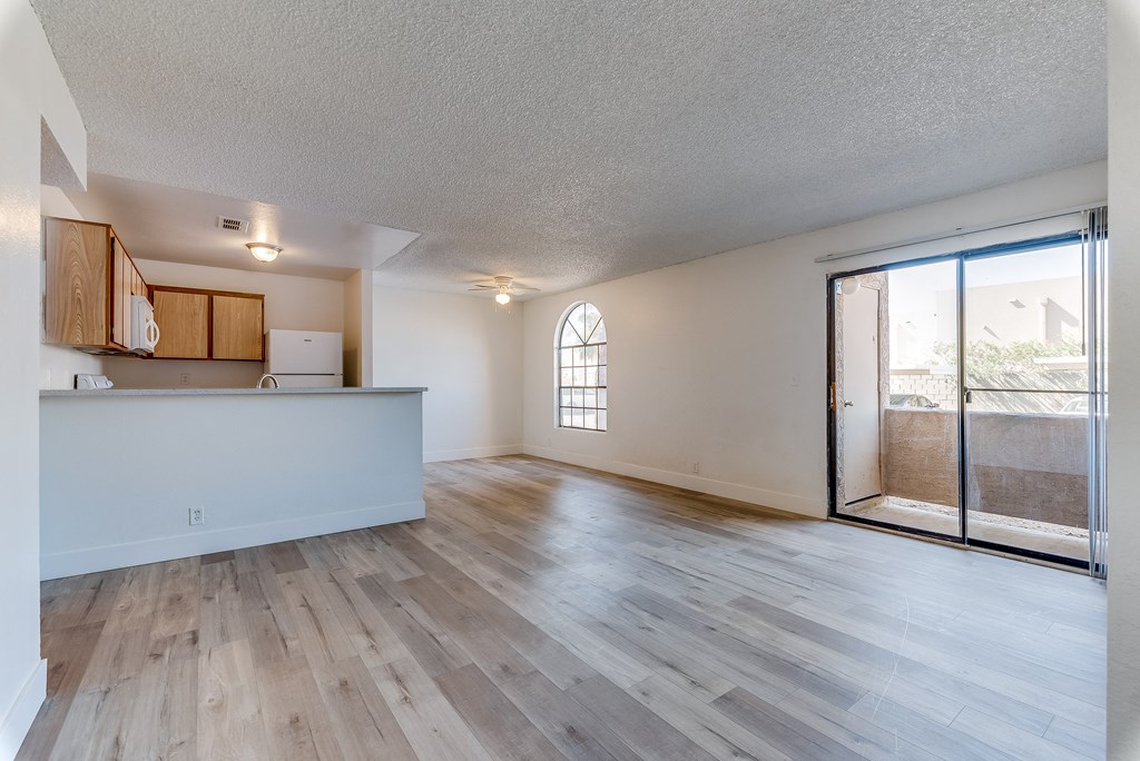 an open living room and kitchen with a sliding glass door to a balcony at Pacific Harbors Sunrise Apartments, Las Vegas, NV