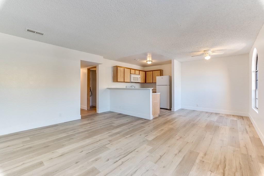 an empty living room with a kitchen in the background at Pacific Harbors Sunrise Apartments, Nevada