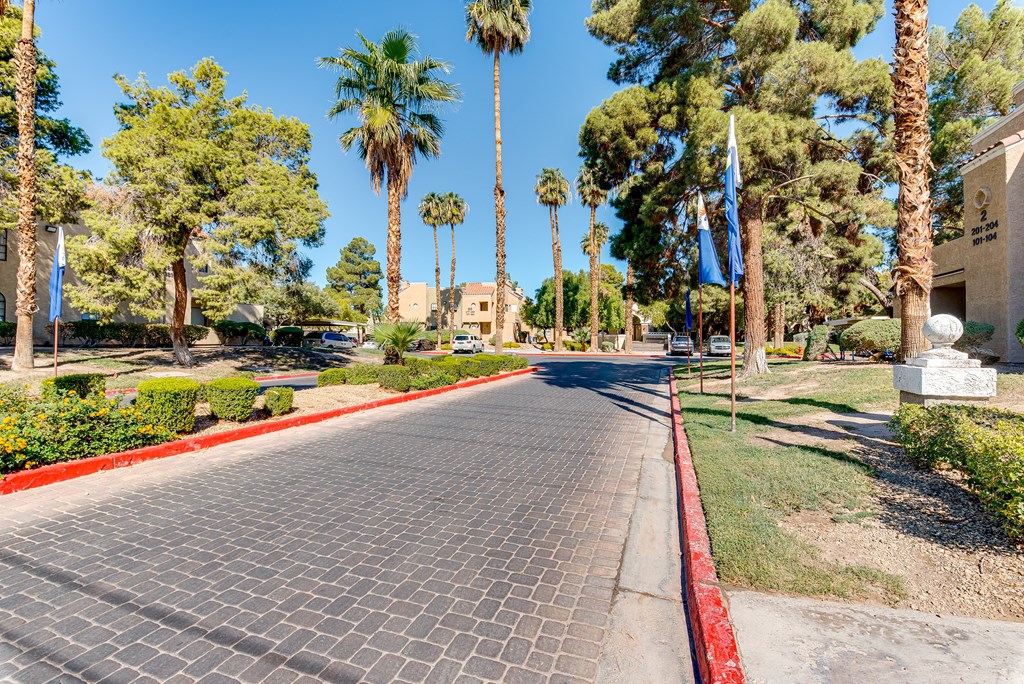 a paved street with palm trees on both sides at Pacific Harbors Sunrise Apartments, Las Vegas, NV