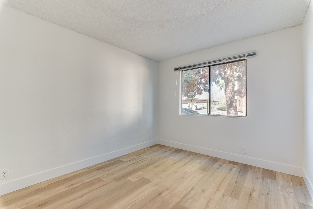 a bedroom with hardwood floors and a large window at Pacific Harbors Sunrise Apartments, Nevada, 89142