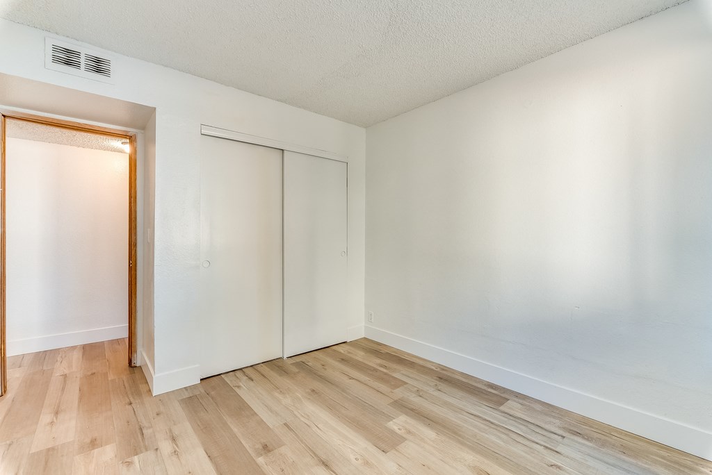 a bedroom with hardwood floors and white walls at Pacific Harbors Sunrise Apartments, Nevada