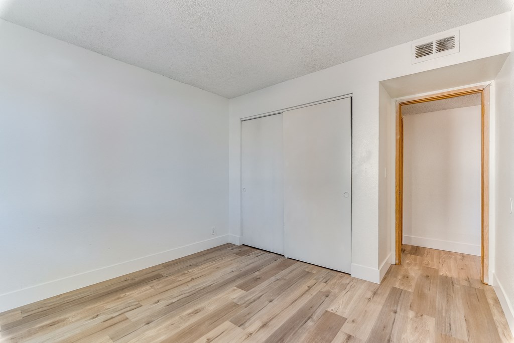 a bedroom with hardwood floors and white walls at Pacific Harbors Sunrise Apartments, Las Vegas, Nevada