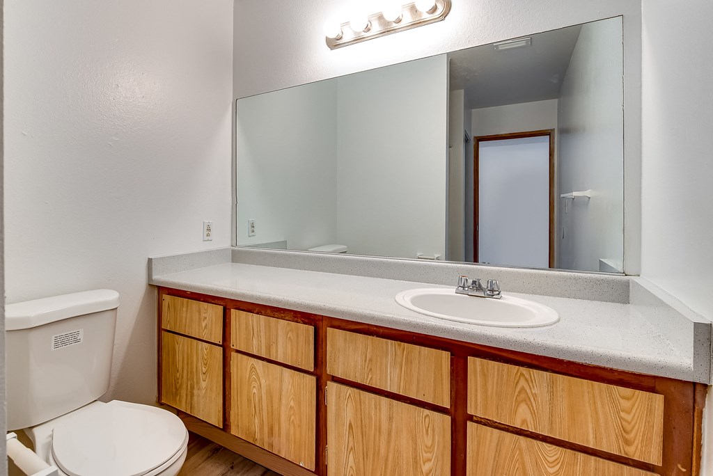 a bathroom with a toilet sink and mirror at Pacific Harbors Sunrise Apartments, Las Vegas, NV, 89142