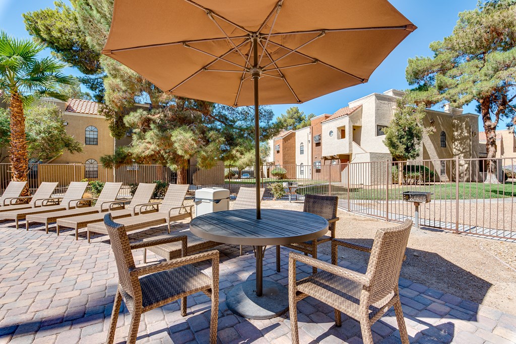 a patio with a table and chairs and an umbrella at Pacific Harbors Sunrise Apartments, Nevada, 89142