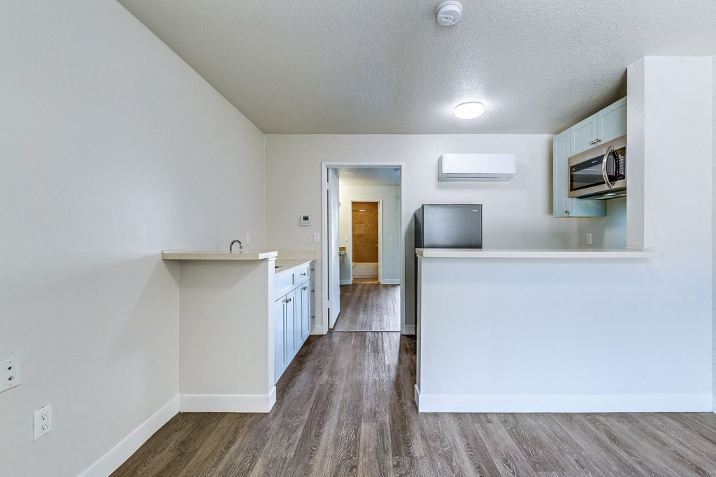 an empty kitchen with a counter top and a microwave