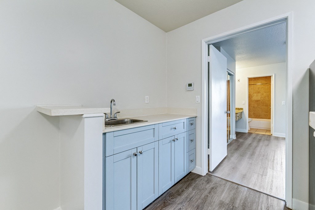 an empty kitchen with blue cabinets and a sink