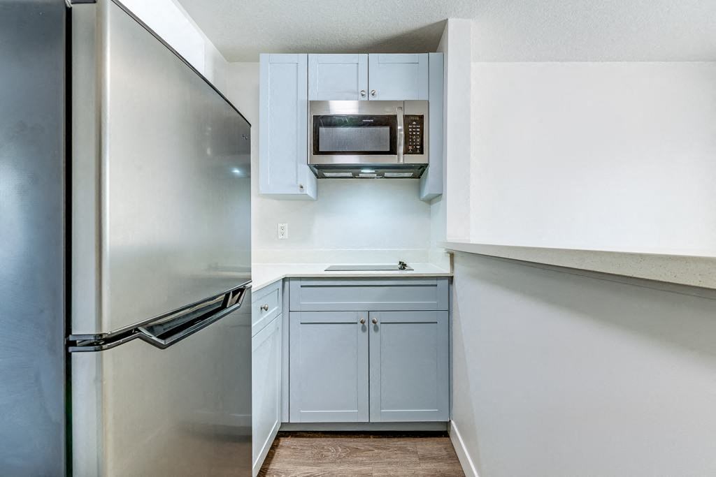 a kitchen with white cabinets and a stainless steel refrigerator