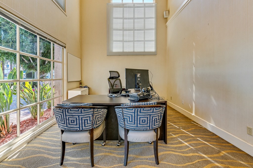 an office with a desk and chairs and a window