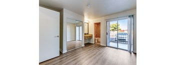A room with a sliding glass door leading to a balcony.