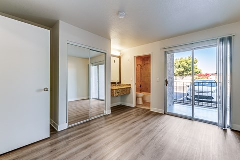 A room with a sliding glass door leading to a balcony.