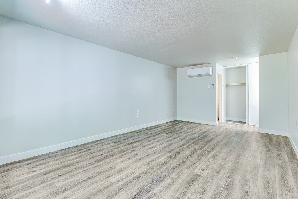 an empty living room with wood flooring and blue walls