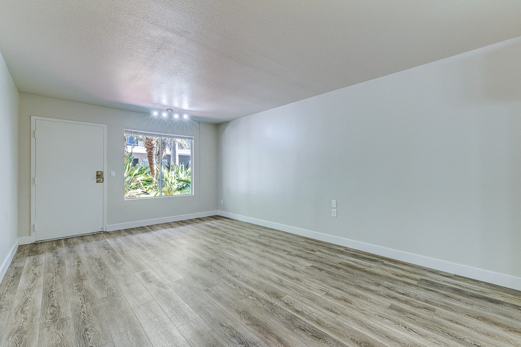 an empty living room with white walls and a window