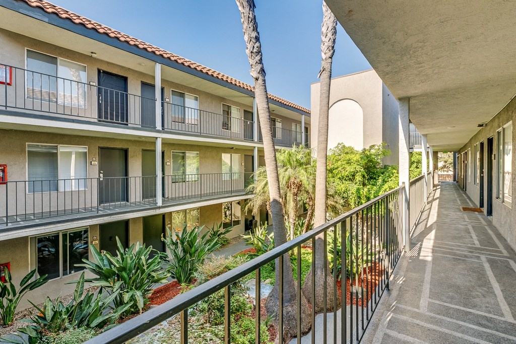 a balcony view of a building with palm trees