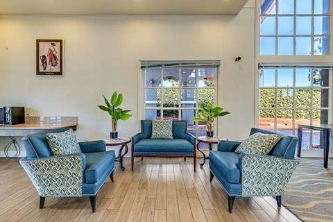 a living room with blue couches and chairs and a window