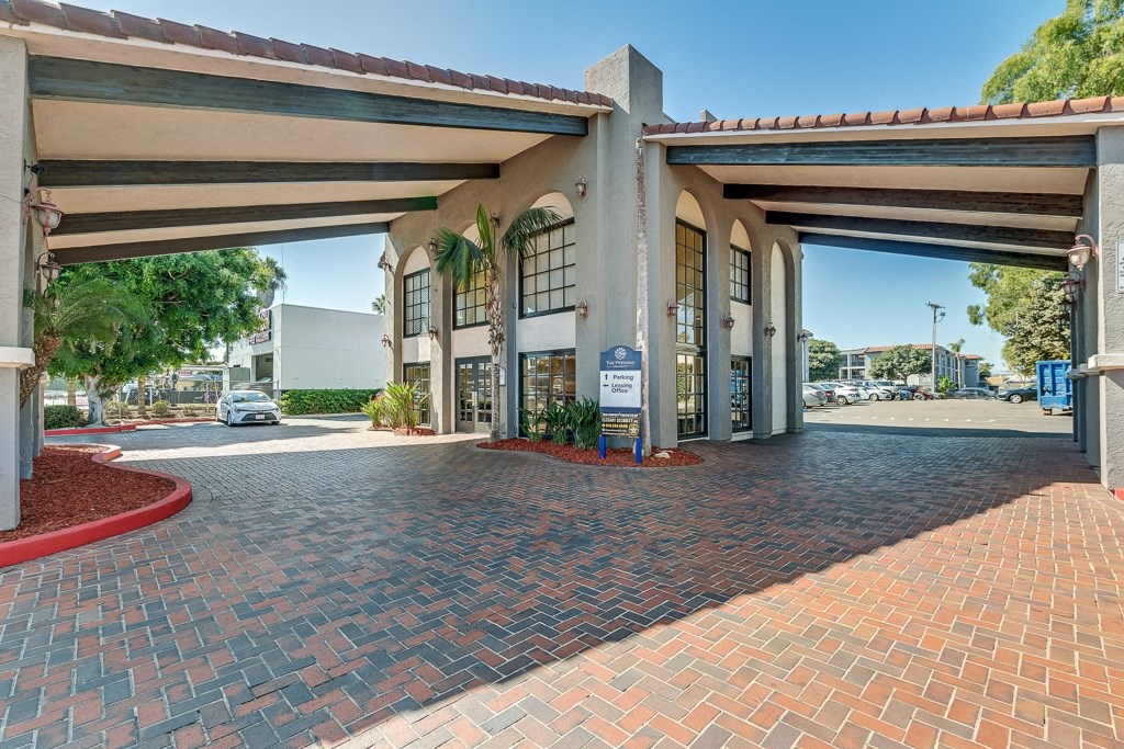 a large building with a driveway and a parking garage