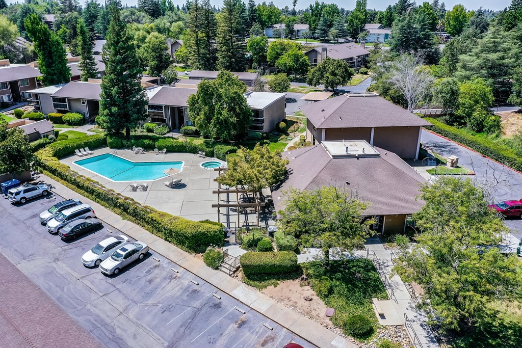 an aerial view of a home with a swimming pool and parking lot