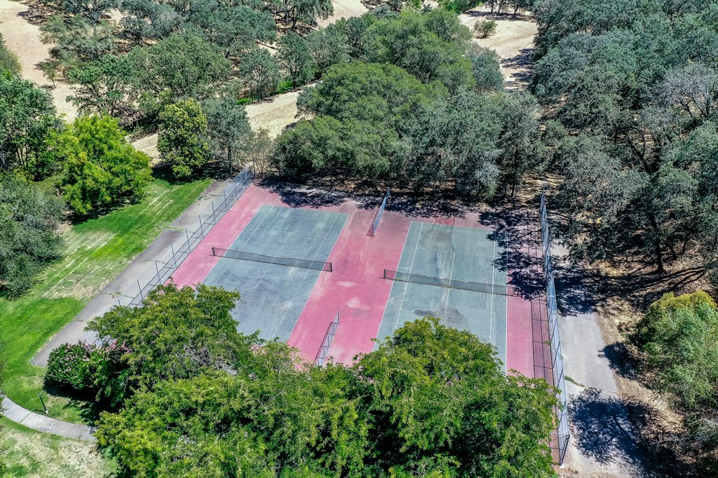 an aerial view of a tennis court surrounded by trees