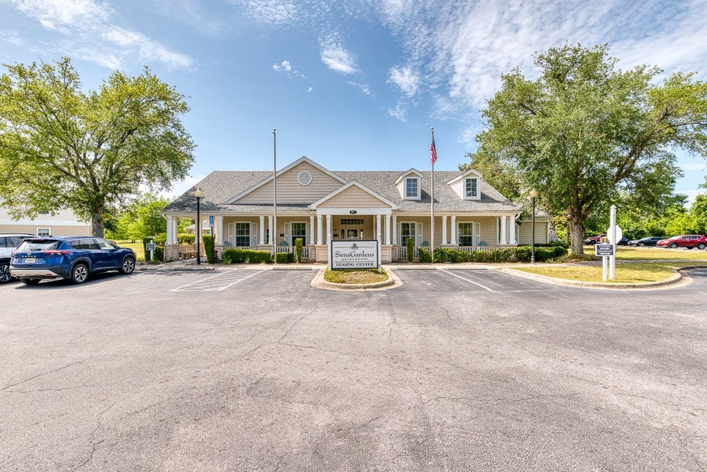 A large building with a flag on top and a sign in front.