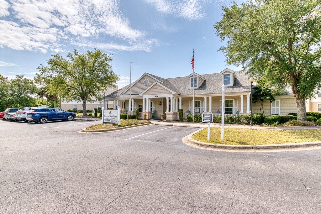 A building with a flag on top and a sign in front.