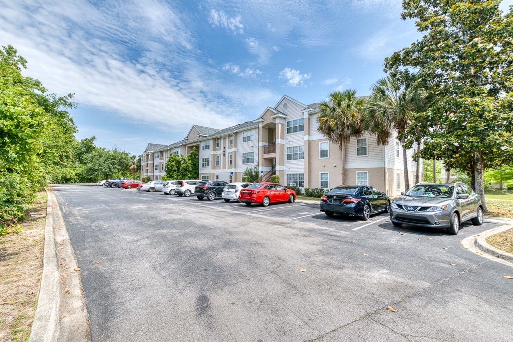 A parking lot with cars and a building in the background.