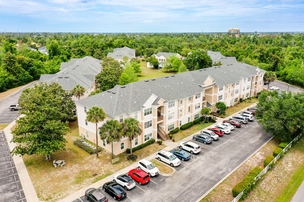 A parking lot with cars and a building in the background.