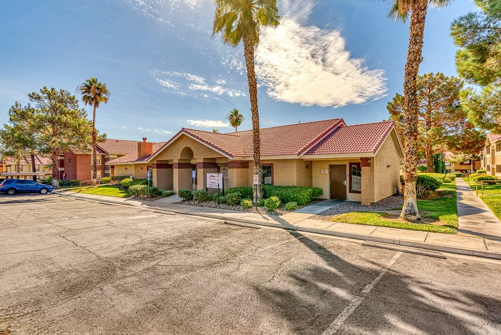 a building with a parking lot and palm trees