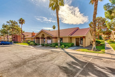 a building with a parking lot and palm trees