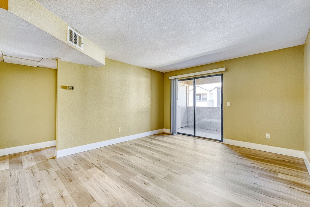 the spacious living room with sliding glass door to the patio