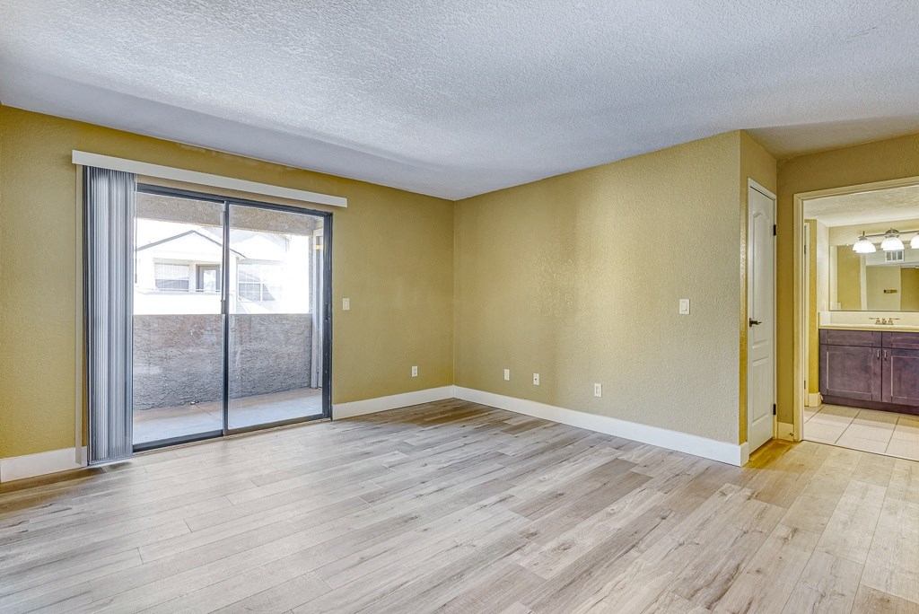 an empty living room with a sliding glass door to a patio