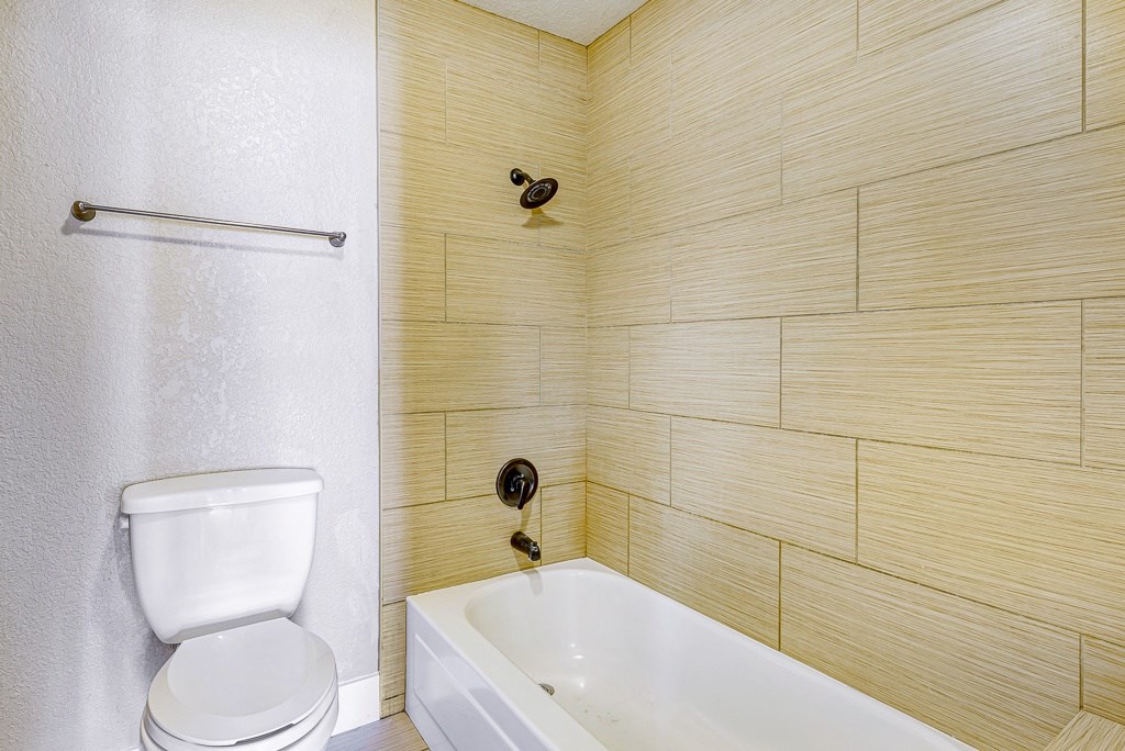 a bathroom with a toilet and a tub and a sink