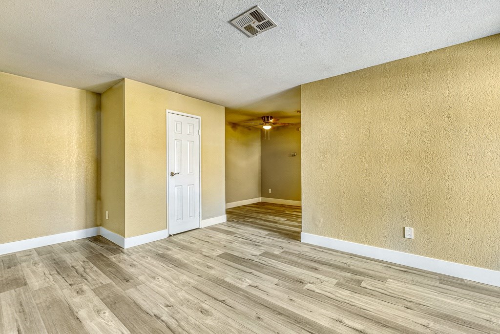 the living room and dining room of an empty house with wood floors