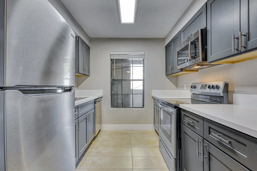 a kitchen with stainless steel appliances and white counter tops